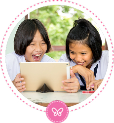 Two smiling school girls in white uniforms are enthusiastically looking at a tablet together, with one of them laughing. This image represents personalized or collaborative learning.